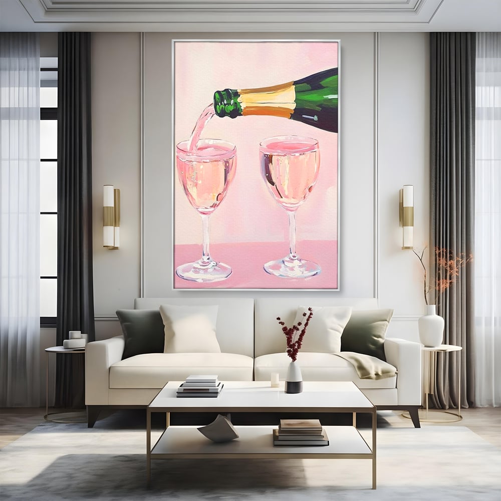 Tablou canvas cu pictura cu sticla si pahare de sampanie roz, in rama de aluminiu argintiu, pe perete intr-un living