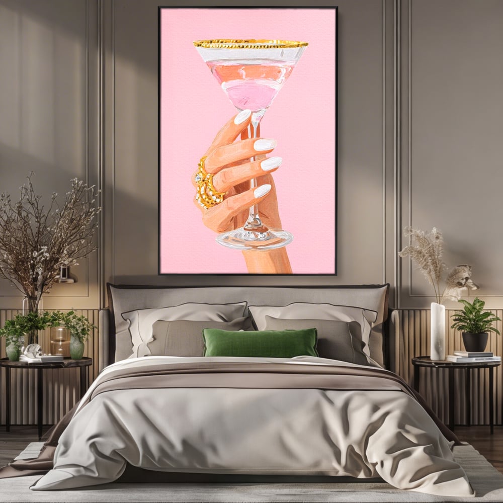 Tablou canvas cu ilustratie cu mana care tine pahar de cocktail, in rama de aluminiu negru, pe perete intr-un dormitor