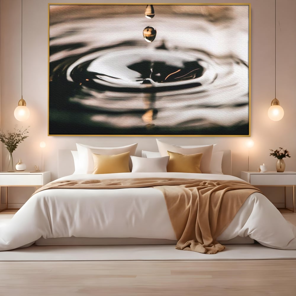 Tablou canvas cu picatura de apa cazand in valuri, in rama de aluminiu auriu, pe perete intr-un dormitor