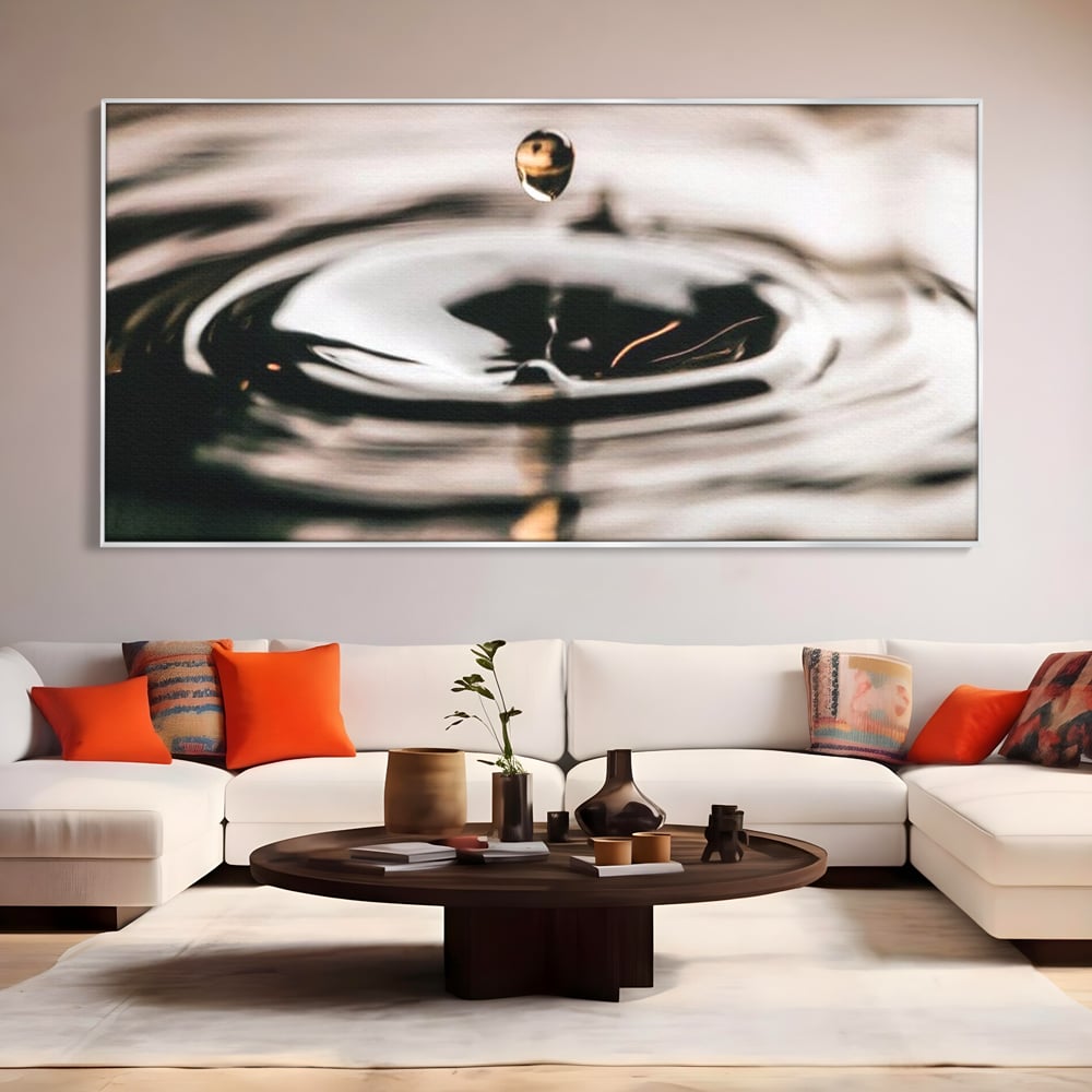 Tablou canvas cu picatura de apa cazand in valuri, in rama de aluminiu argintiu, pe perete intr-un living