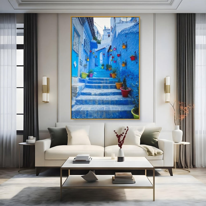 Tablou canvas cu tablou canvas cu straduta albastra din maroc, in rama de aluminiu auriu, pe perete intr-un living