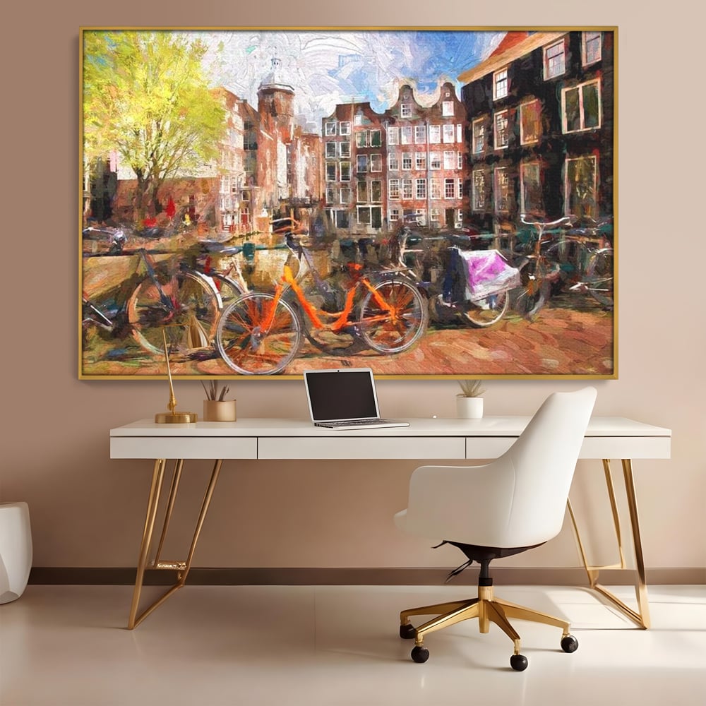 Tablou canvas cu pictura stradala cu bicicleta portocalie, in rama de aluminiu auriu, pe perete intr-un birou