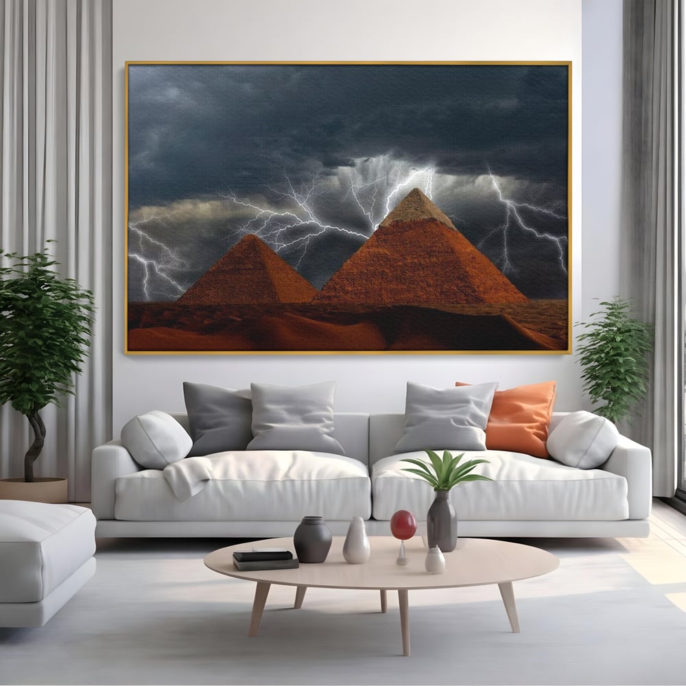 Tablou canvas cu ilustratie cu piramide si fulgere, in rama de aluminiu auriu, pe perete intr-un living