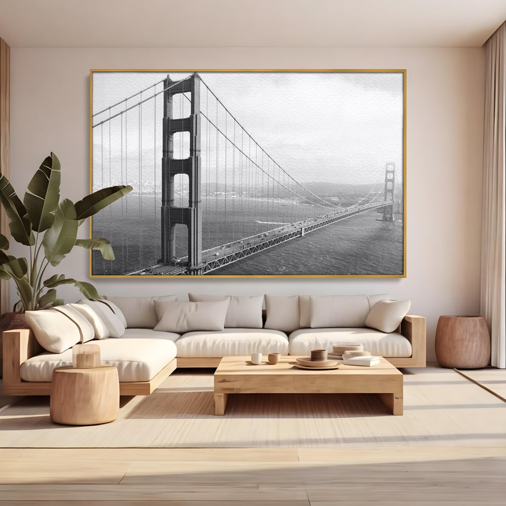 Tablou canvas cu fotografie alb-negru cu podul golden gate, in rama de aluminiu auriu, pe perete intr-un living