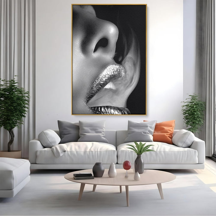 Tablou canvas cu tablou canvas cu buze si fum, in rama de aluminiu auriu, pe perete intr-un living