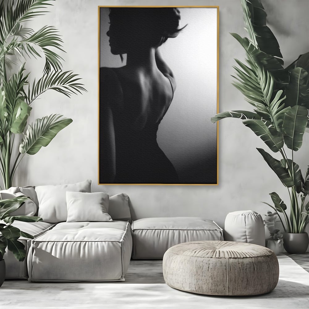 Tablou canvas cu tablou canvas cu silueta feminina monocroma, in rama de aluminiu auriu, pe perete intr-un living