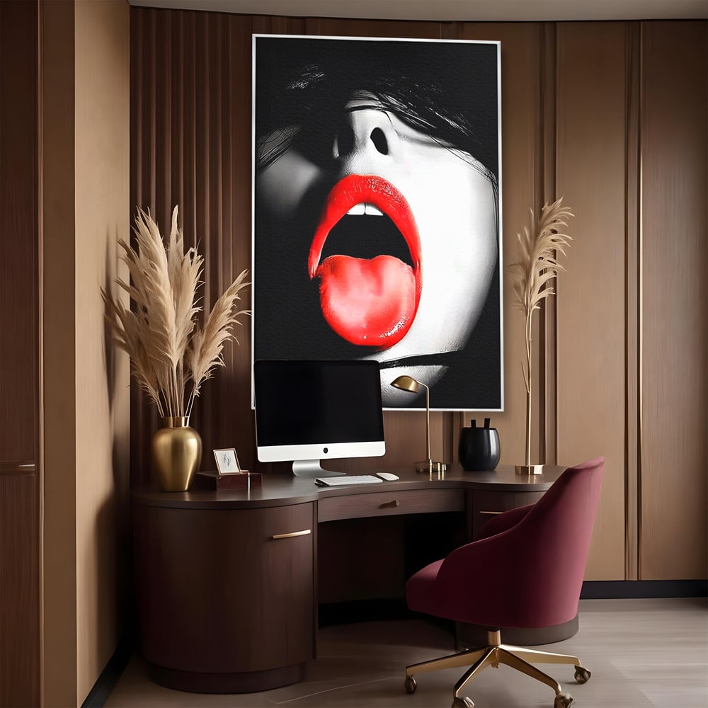 Tablou canvas cu tablou canvas cu buze si limba rosie, in rama de aluminiu argintiu, pe perete intr-un birou