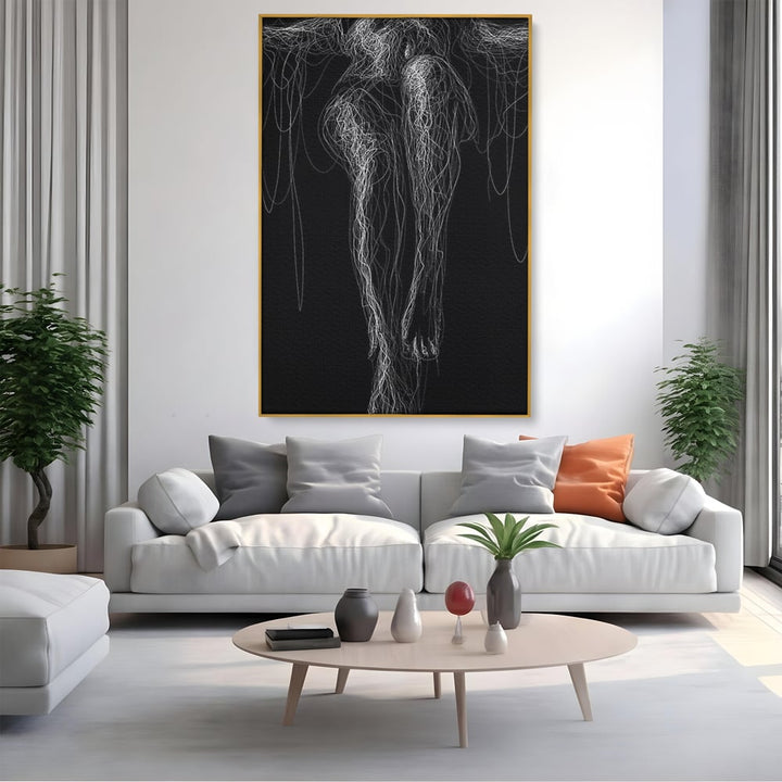 Tablou canvas cu silueta feminina din linii albe pe fond negru, in rama de aluminiu auriu, pe perete intr-un living
