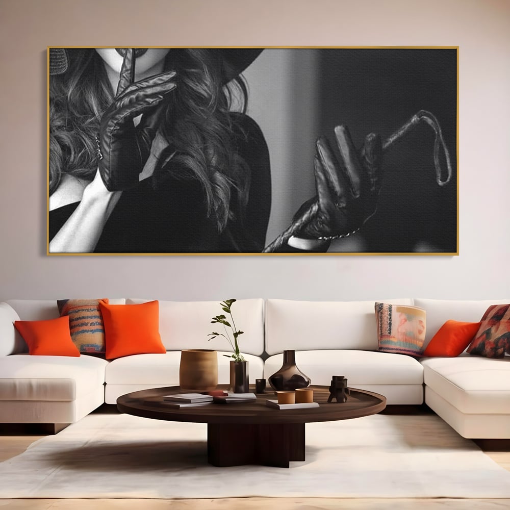 Tablou canvas cu tablou canvas cu femeie in palarie si manusi negre, in rama de aluminiu auriu, pe perete intr-un living