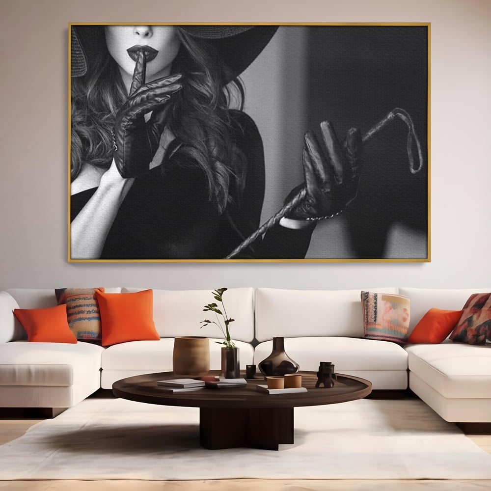 Tablou canvas cu tablou canvas cu femeie in palarie si manusi negre, in rama de aluminiu auriu, pe perete intr-un living