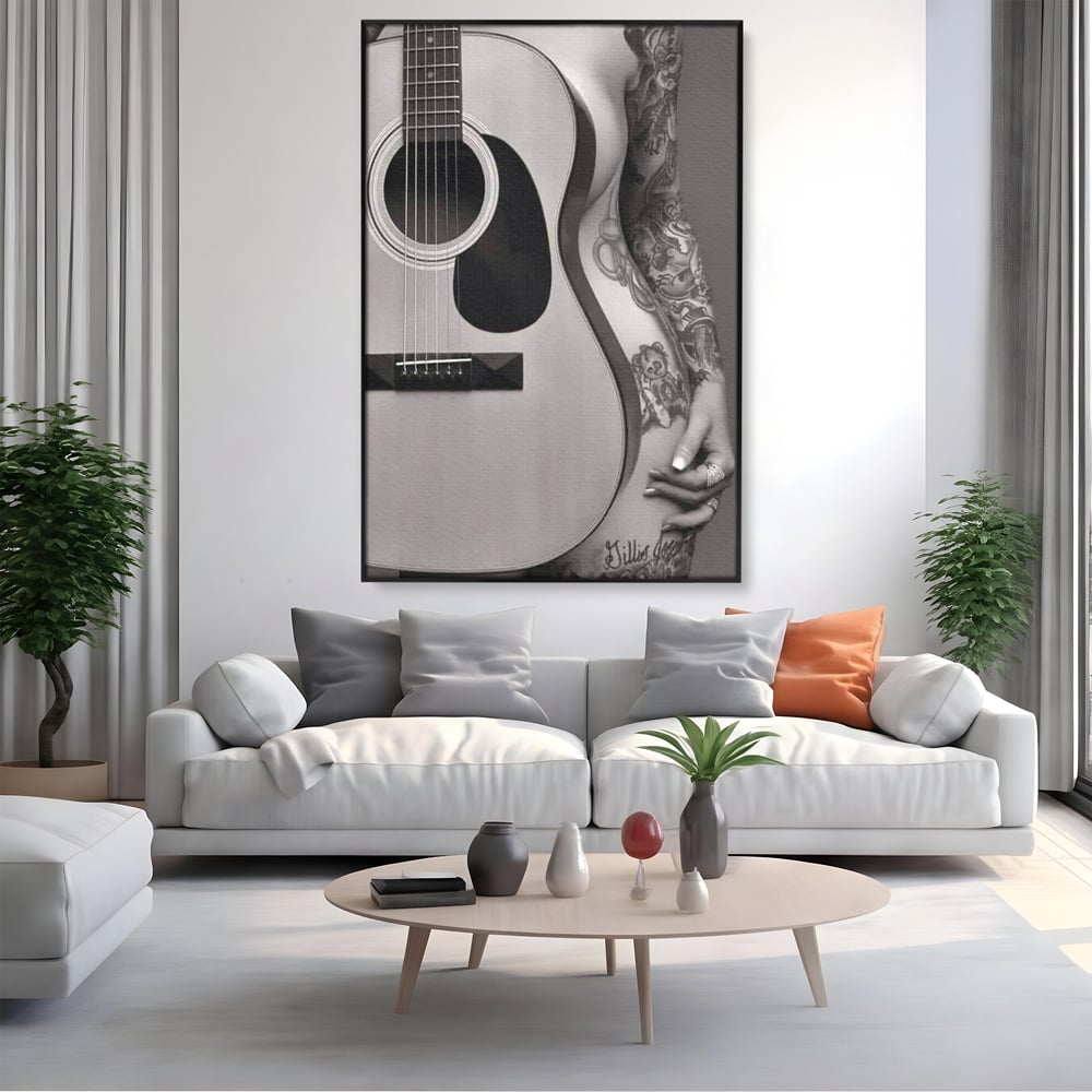 Tablou canvas cu tablou canvas cu chitara si silueta feminina tatuata, in rama de aluminiu negru, pe perete intr-un living