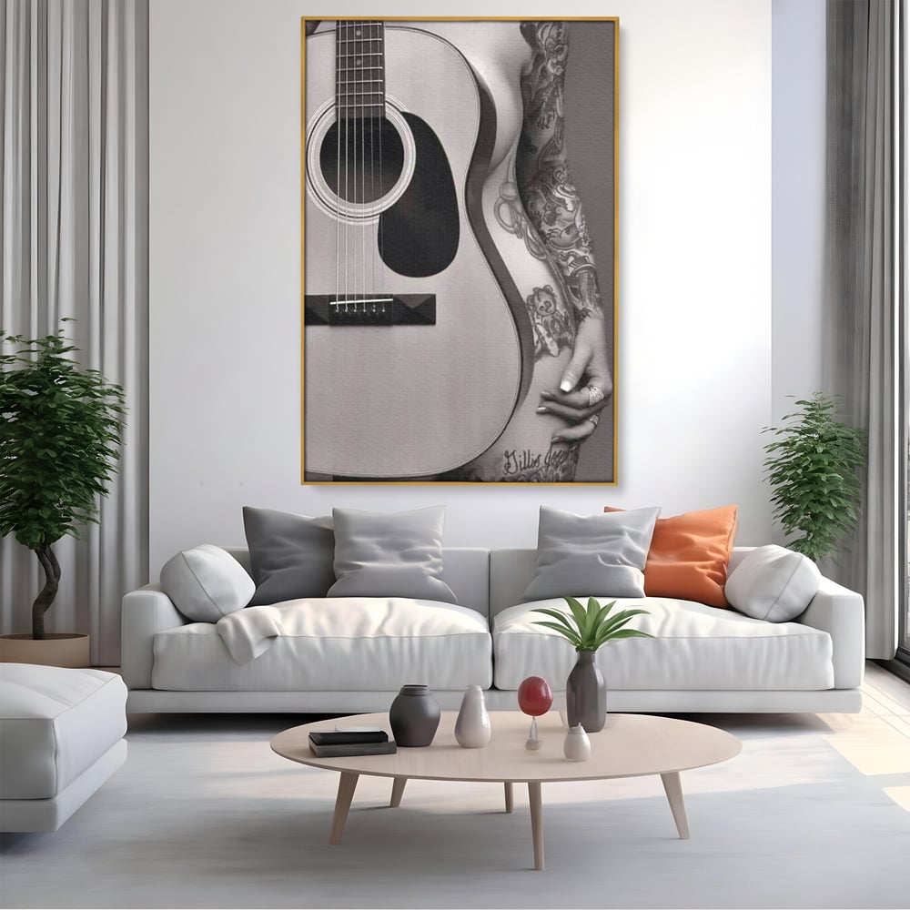 Tablou canvas cu tablou canvas cu chitara si silueta feminina tatuata, in rama de aluminiu auriu, pe perete intr-un living