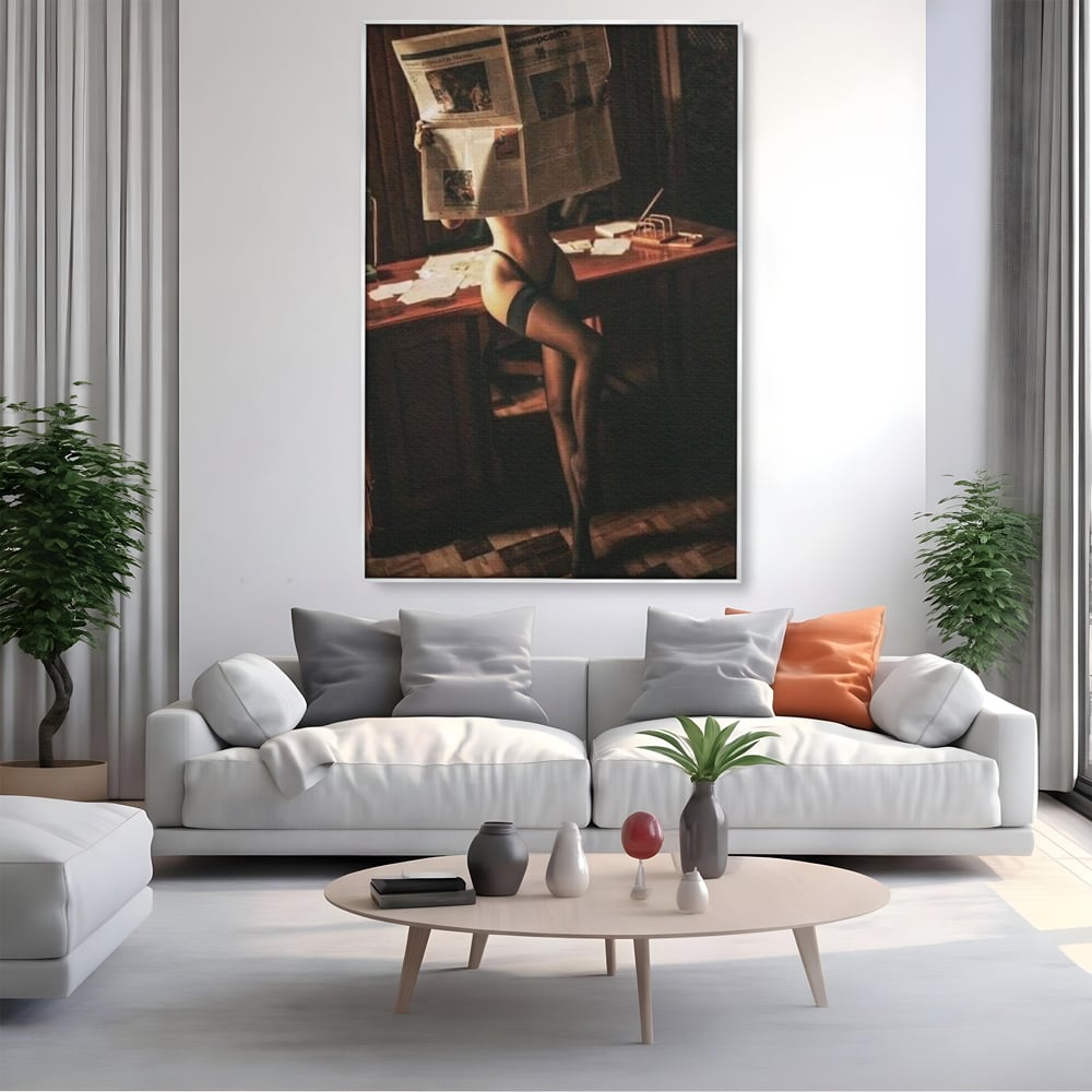 Tablou canvas cu tablou canvas cu femeie si ziar, in rama de aluminiu argintiu, pe perete intr-un living
