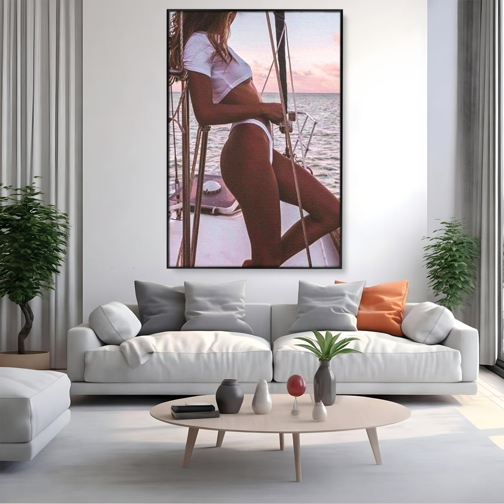 Tablou canvas cu tablou canvas cu femeie pe corabie, in rama de aluminiu negru, pe perete intr-un living