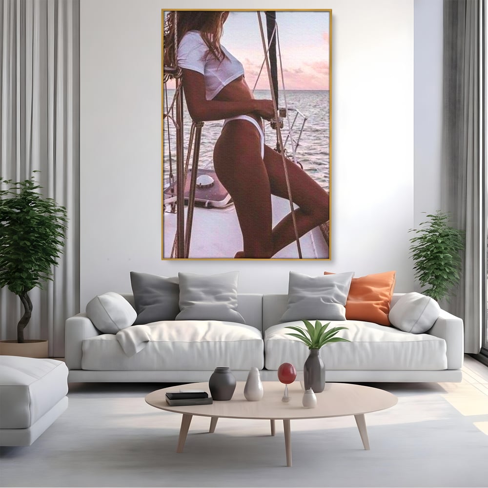 Tablou canvas cu tablou canvas cu femeie pe corabie, in rama de aluminiu auriu, pe perete intr-un living