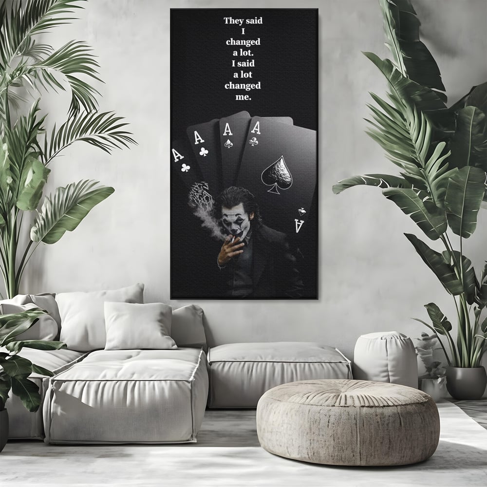 Tablou canvas cu tablou motivational cu joker si carti de joc, in rama de aluminiu negru, pe perete intr-un living