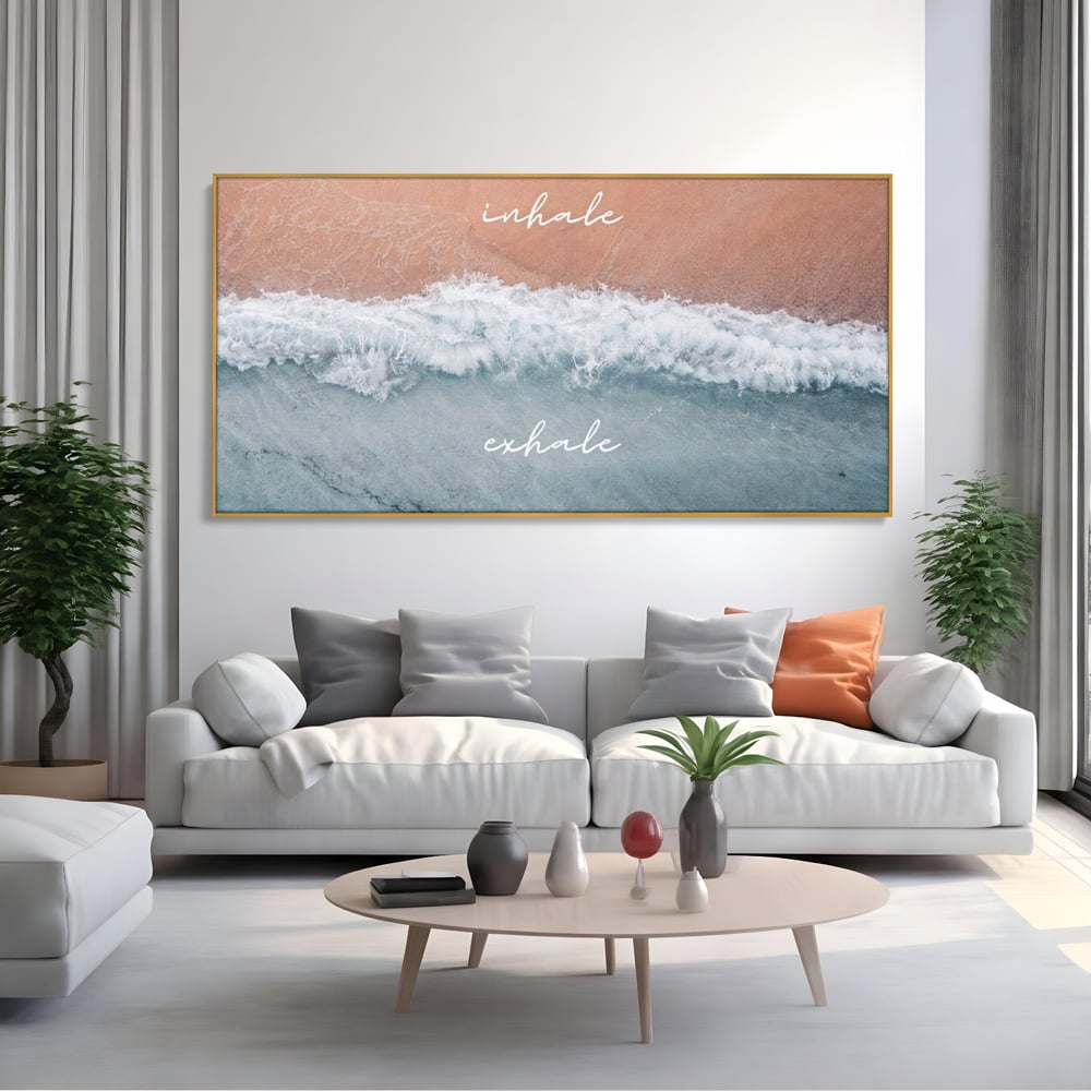 Tablou canvas cu tablou canvas cu plaja si valuri, in rama de aluminiu auriu, pe perete intr-un living