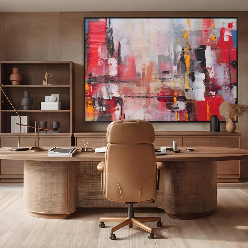 Tablou canvas cu pictura abstracta cu pete de rosu si galben, in rama de aluminiu negru, pe perete intr-un birou