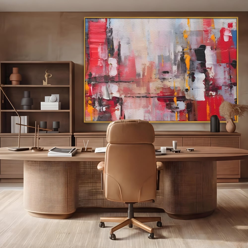 Tablou canvas cu pictura abstracta cu pete de rosu si galben, in rama de aluminiu auriu, pe perete intr-un birou
