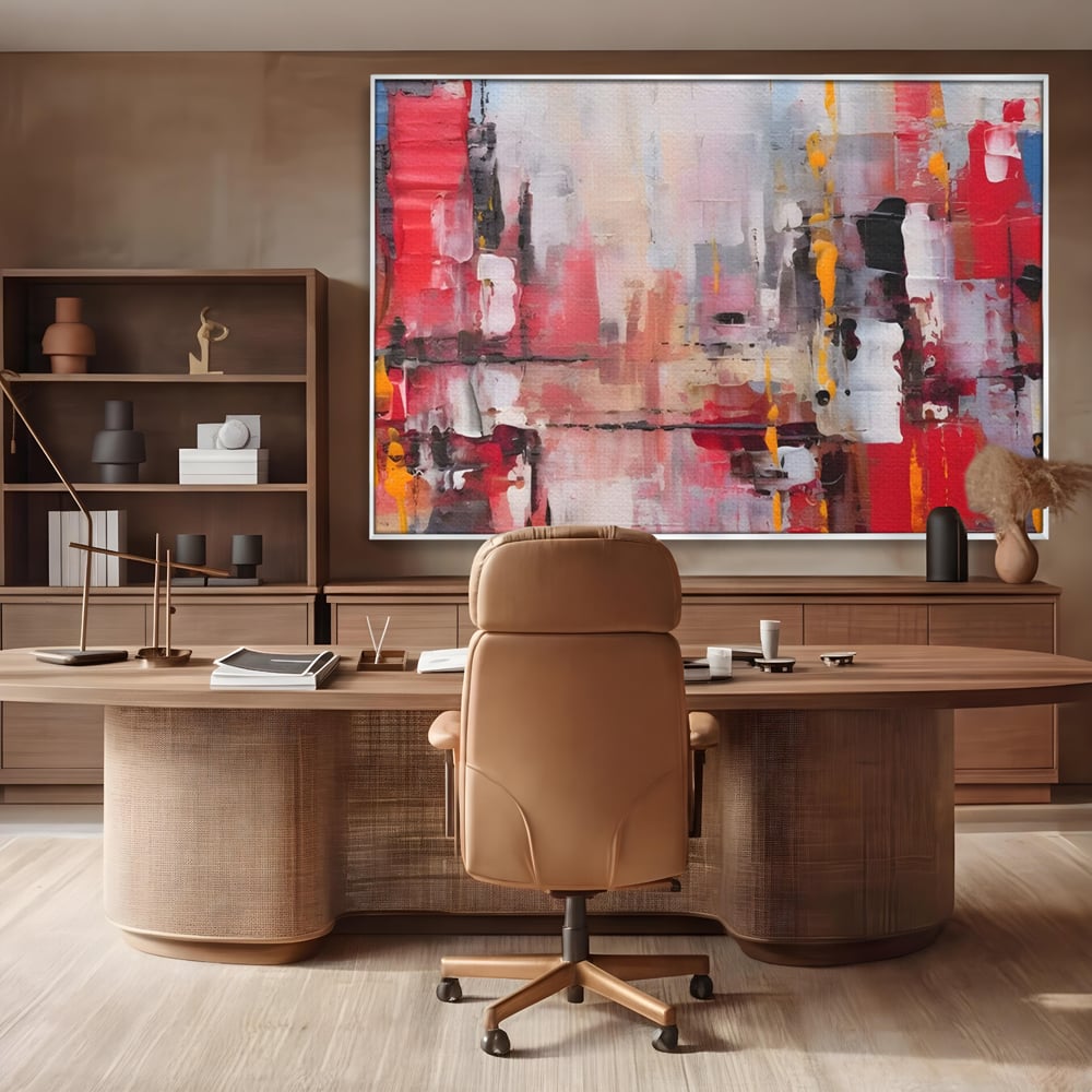 Tablou canvas cu pictura abstracta cu pete de rosu si galben, in rama de aluminiu argintiu, pe perete intr-un birou