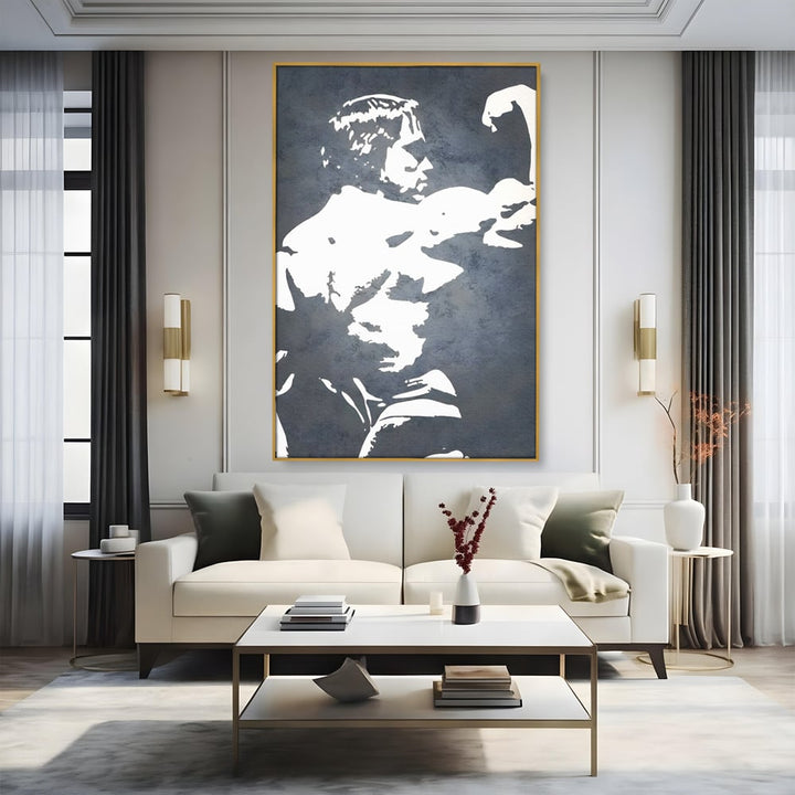 Tablou canvas cu tablou canvas cu portret stilizat, in rama de aluminiu auriu, pe perete intr-un living